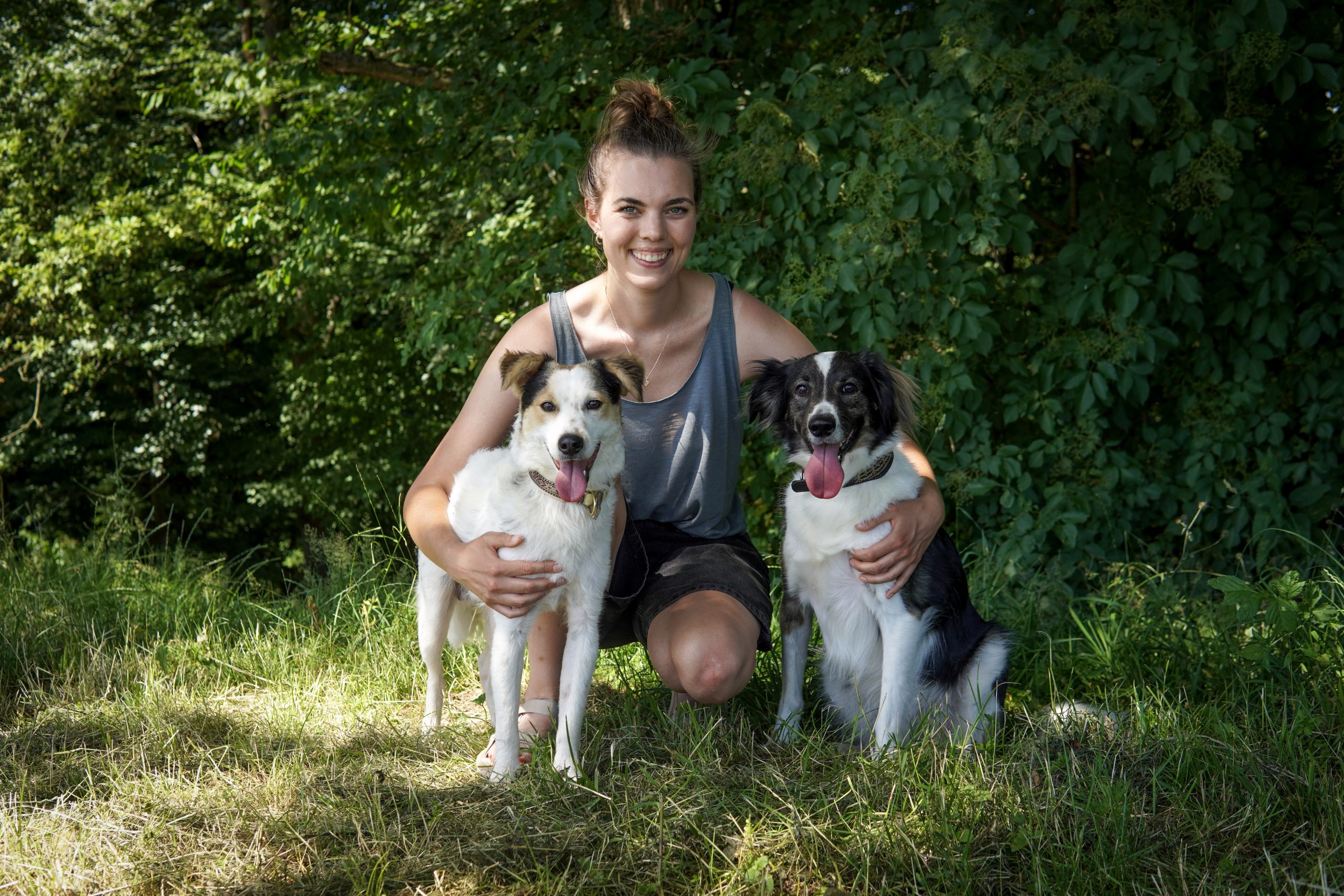 Judith hockend mit ihren Hunden Pip (links) und Cem (rechts)